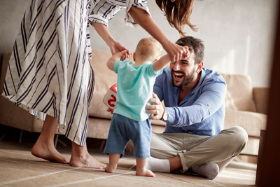 young couple and baby learning to walk, happy concept