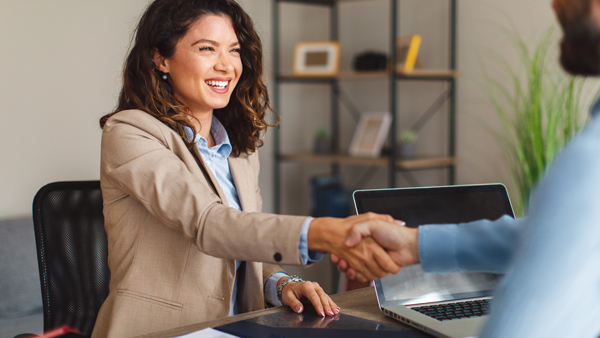 smiling woman shaking financial advisers hand