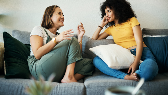 women, friends relaxing and conversation at a home, happy in a living room